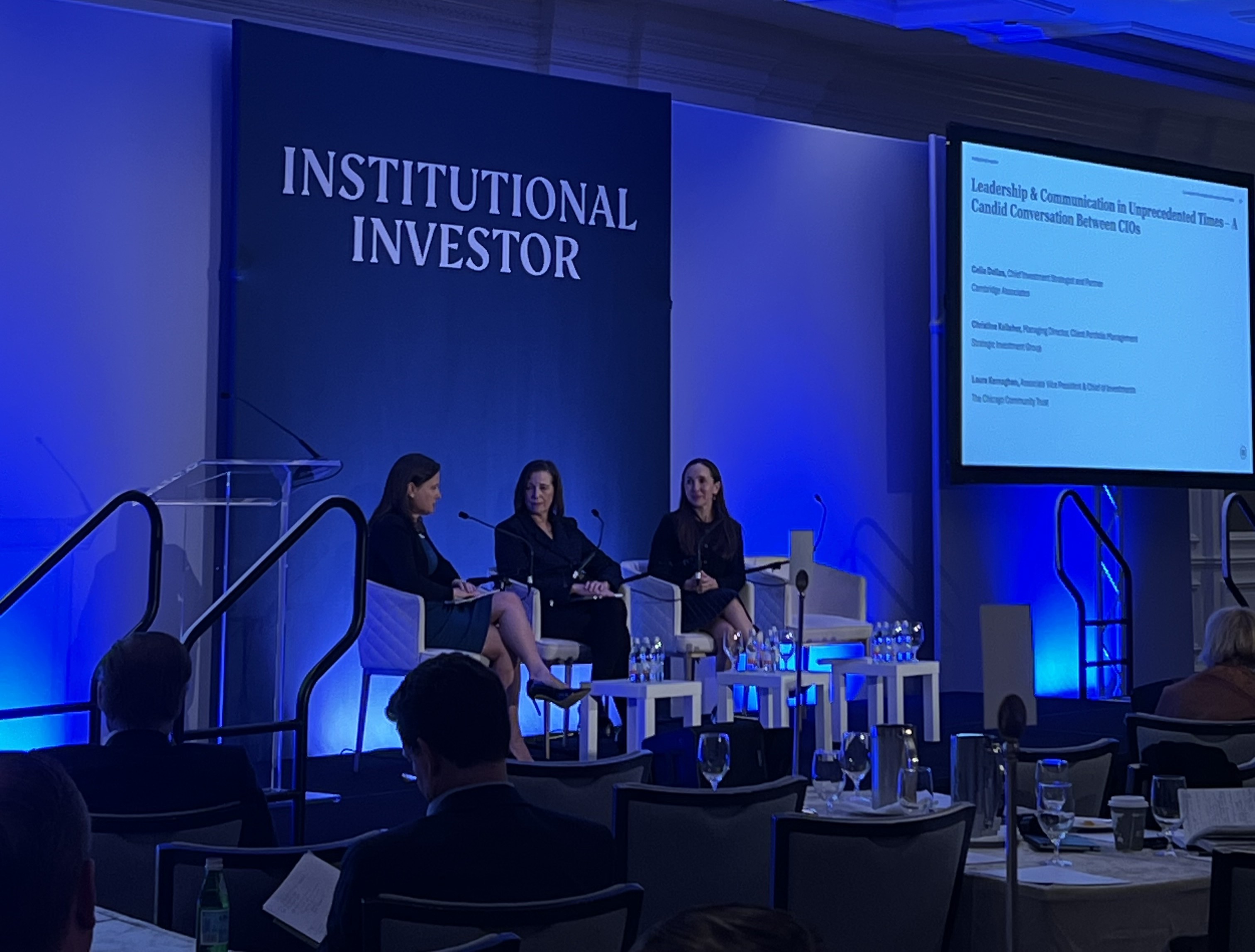 three people on a panel on a stage